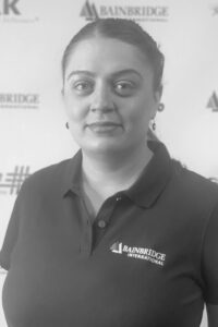 A woman in black shirt standing next to wall.