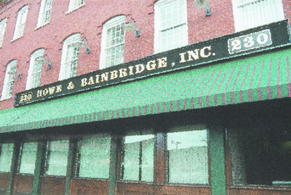 A building with a green awning and brown doors.