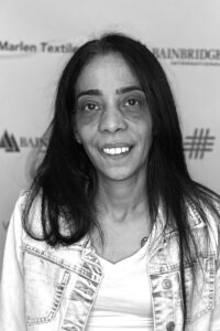 A woman with long hair and a white shirt.